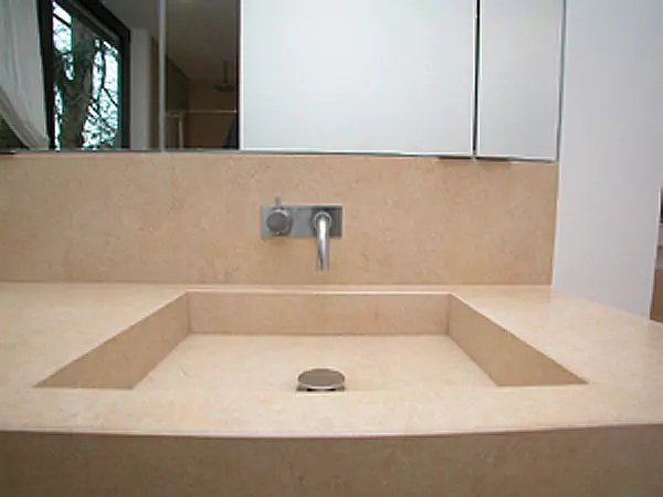 Ein sandfarbenes Steinwaschbecken in einem Badezimmer