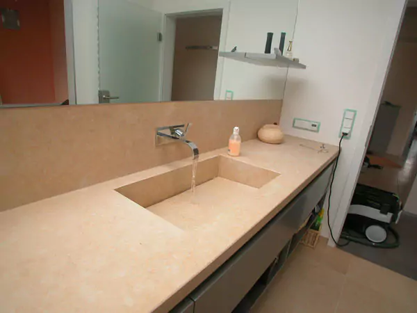 Ein sandfarbenes Steinwaschbecken in einem Badezimmer