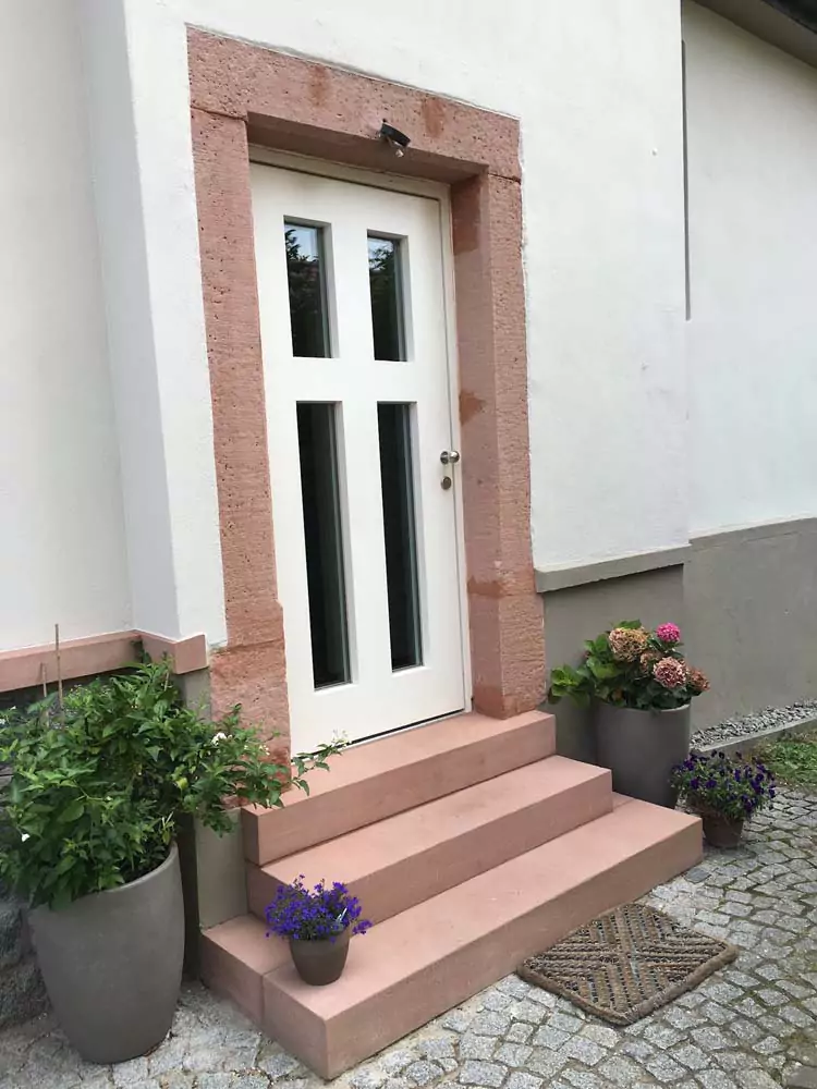 Eine neu sanierte Steintreppe vor einem historischem Haus