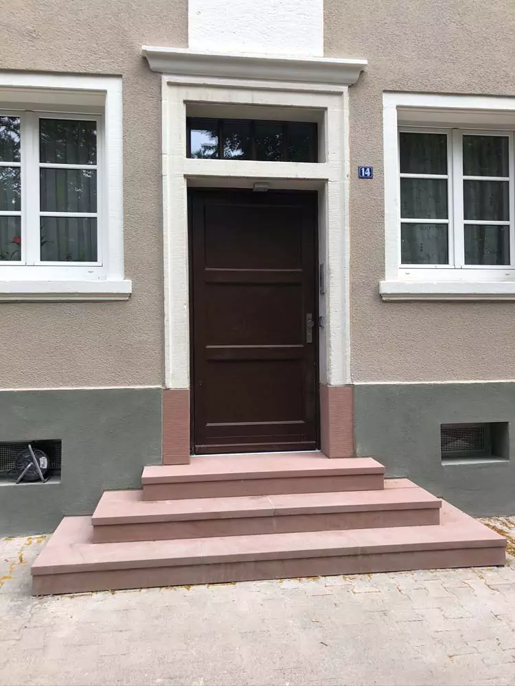 Eine neu sanierte Steintreppe vor einem historischem Haus