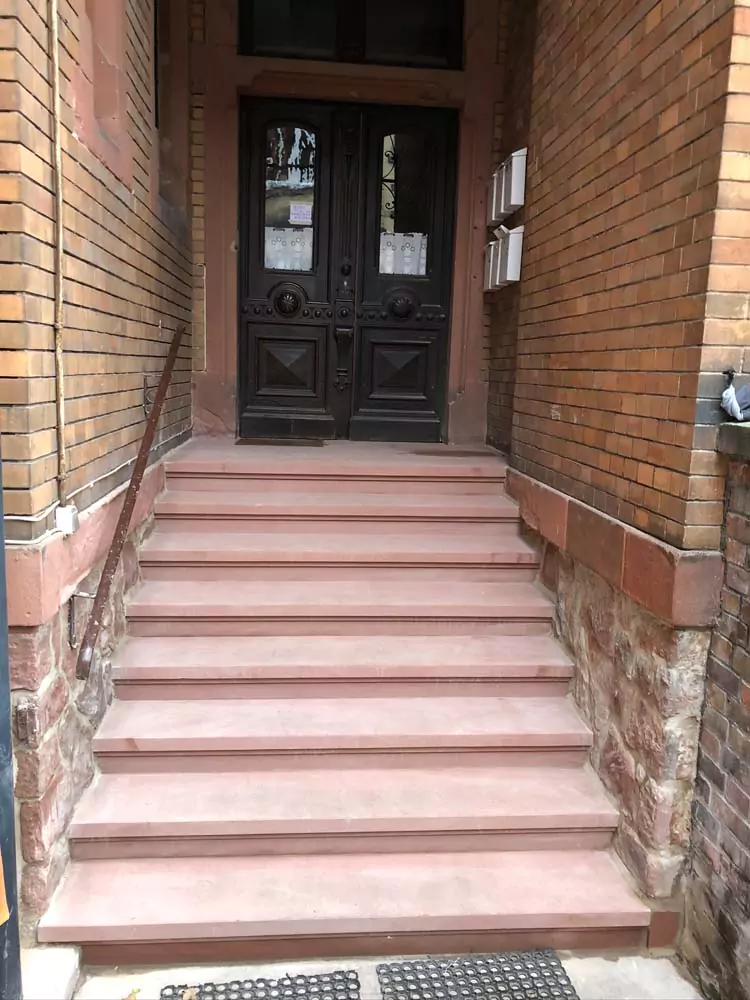 Eine neu sanierte Steintreppe vor einem historischem Haus