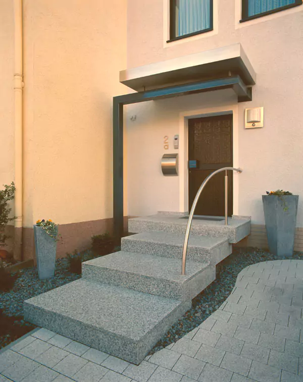 Eine helle Steintreppe als Eingang zu einem Haus